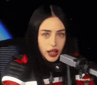 a woman is talking into a microphone with her mouth wide open