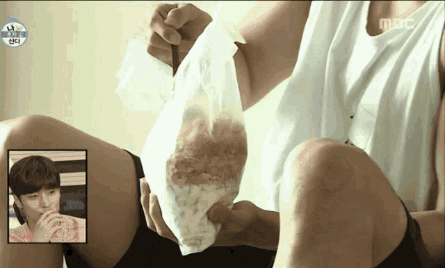 a person holding a bag of food with a picture of a boy in the corner that says mbc