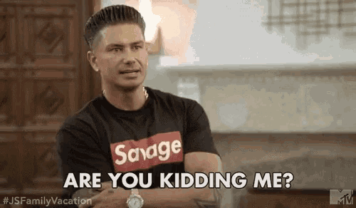 a man wearing a savage t-shirt is asking if he is kidding me .