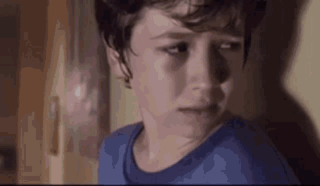 a young boy is crying in a dark room .