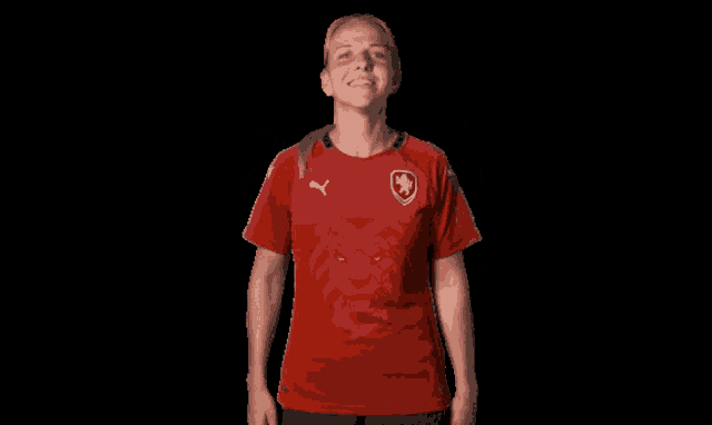 a woman wearing a red puma shirt with a lion on it