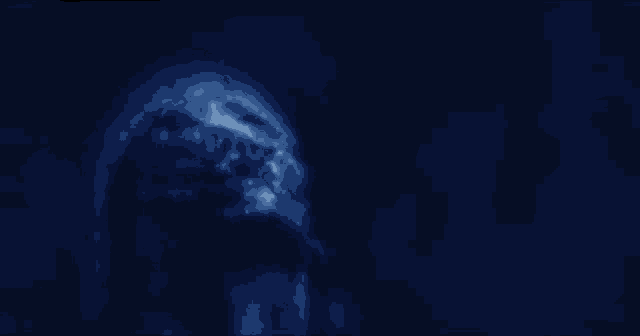 a close up of a person 's face in a dark room .