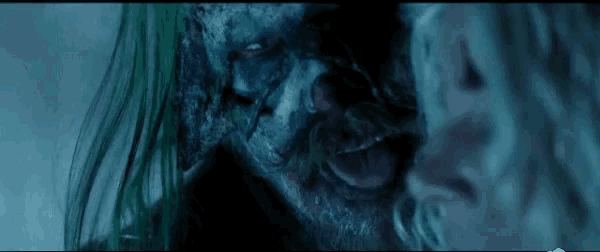 a close up of a zombie with green hair and a beard looking at a woman .