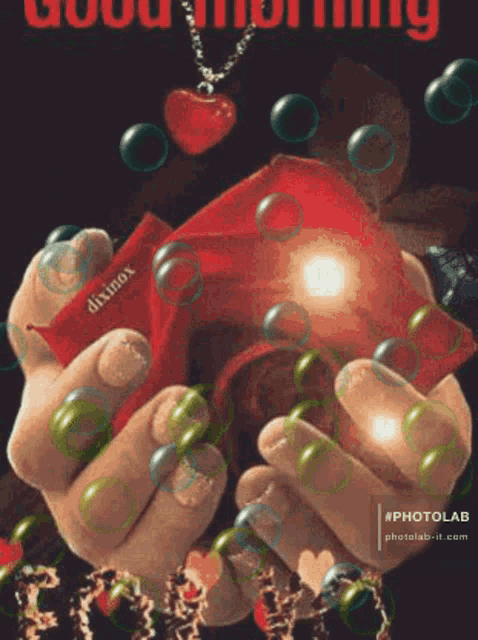a person is holding a red box with a heart shaped pendant on it .
