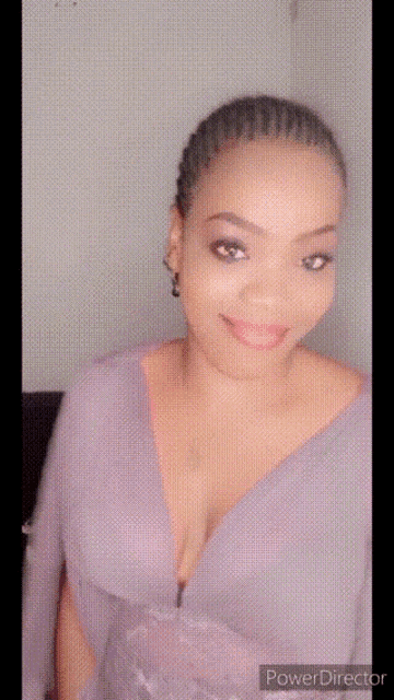 a woman in a purple dress with a plunging neckline is smiling