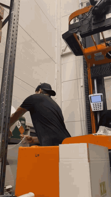a man in a black shirt is working on a forklift with xxl written on the side