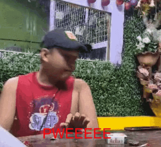 a man sitting at a table with the word pweeeee written on the bottom