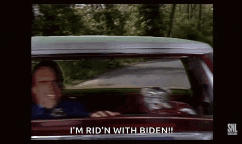 a man is driving a car and says i 'm rid 'n with biden !