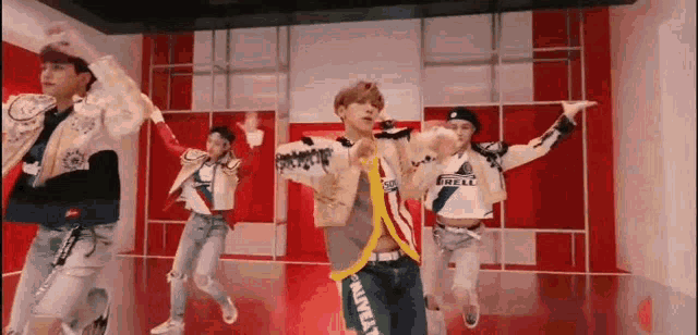 a group of young men are dancing on a stage in a dance studio .