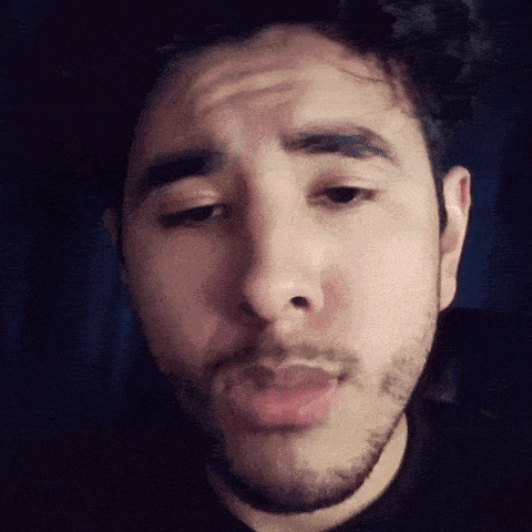 a man with a beard is making a funny face with his eyes closed and his mouth open .