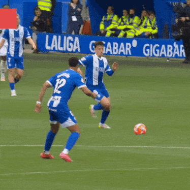 soccer players on a field with a sign that says gigabar in the background