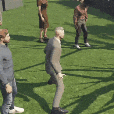 a man in a suit is dancing in the grass with other people
