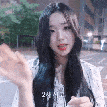 a woman with long black hair is wearing a white shirt with a striped sleeve