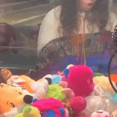 a blurred image of a woman playing a game with stuffed animals including a pink stuffed animal