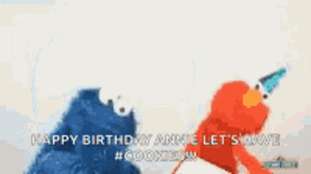 elmo and cookie monster are standing next to each other .
