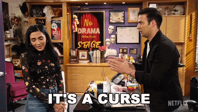 a man and a woman are talking in front of a sign that says no drama stage
