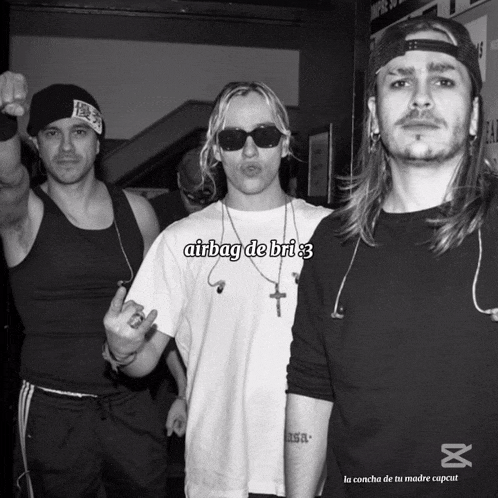 a group of men are posing for a photo and one of them is wearing an airbag de bri shirt