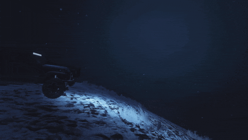 a jeep is parked on top of a snow covered hill at night
