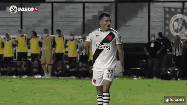a soccer player wearing a jersey with the number 37 on it is standing on the field .
