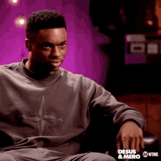 a man is sitting in a chair wearing a showtime sweatshirt