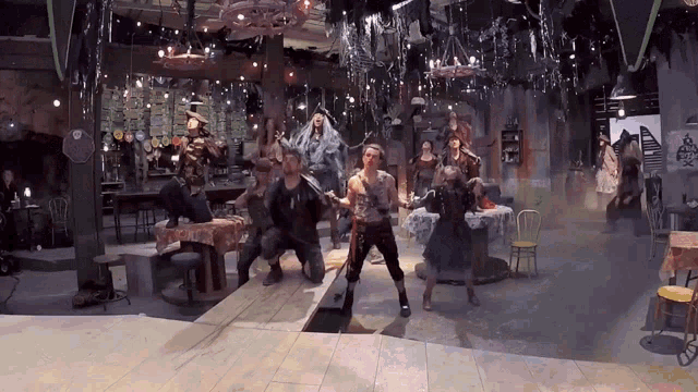 a group of people are dancing in a room with tables and chairs and a sign that says ' fish ' on it