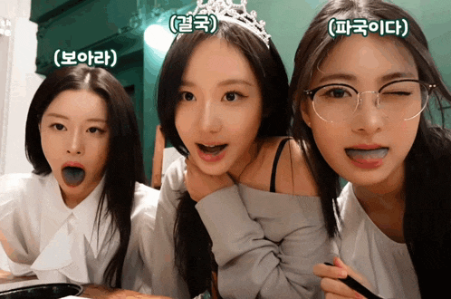 three women with foreign writing on their faces including one wearing a tiara