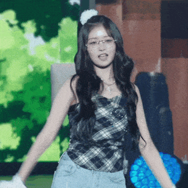 a woman wearing glasses and a plaid top is dancing