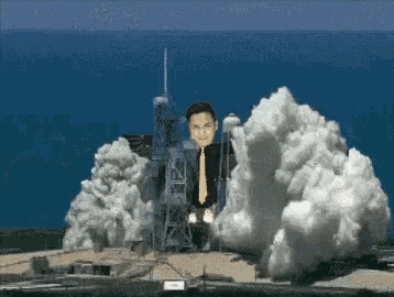 a man in a tie is standing in front of a rocket being launched into space
