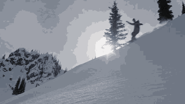 a person snowboarding down a snow covered slope with the sun shining through the trees