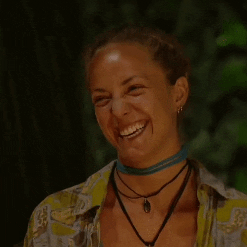 a woman wearing a choker and a necklace is laughing .