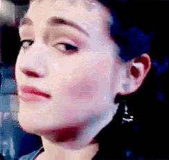 a close up of a woman 's face with a slight smirk on her face .