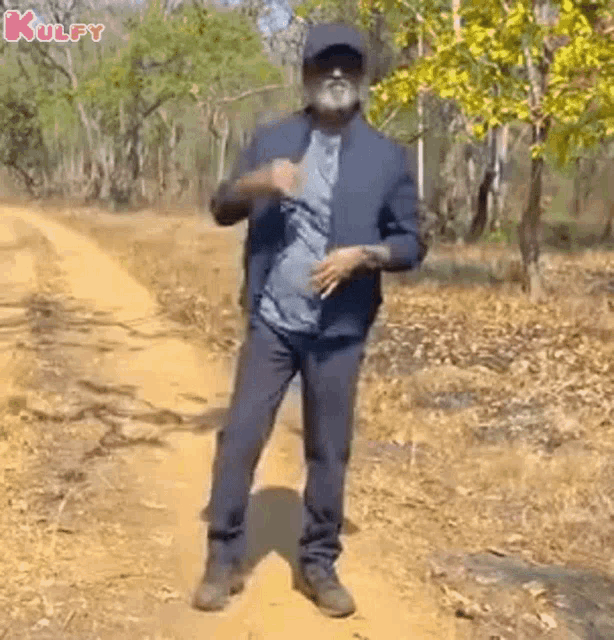 a man in a suit is dancing on a dirt road .