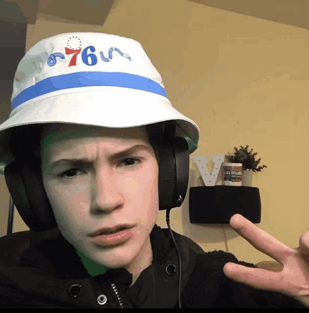 a young man wearing headphones and a white hat with the number 76 on it