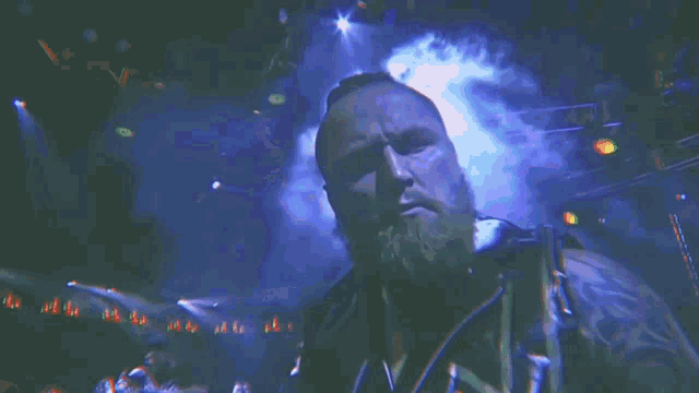 a man is standing in a dark room holding a sword in front of a fire