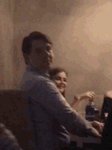a man and a woman are sitting at a table in a room .