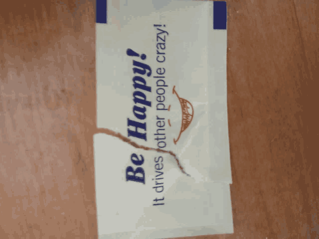 a broken piece of paper that says be happy
