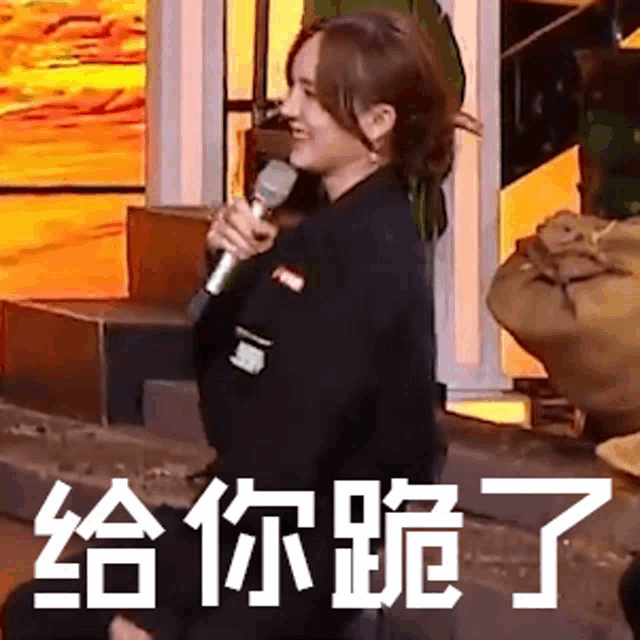 a woman is kneeling down while holding a microphone and making a funny face .