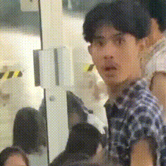 a man in a plaid shirt is looking at the camera .