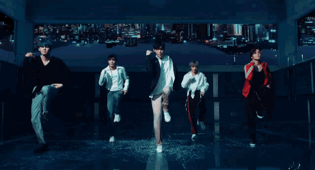 a group of young men are dancing in a room