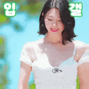 a woman in a white dress is smiling while standing in front of a body of water .