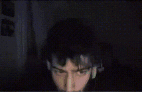 a close up of a man 's face with a green light behind him
