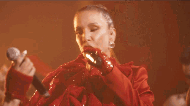 a woman singing into a microphone while standing next to another woman