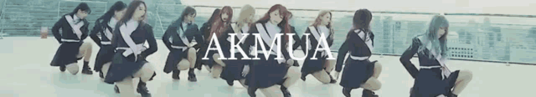 a group of girls are dancing in front of a sign that says akmux
