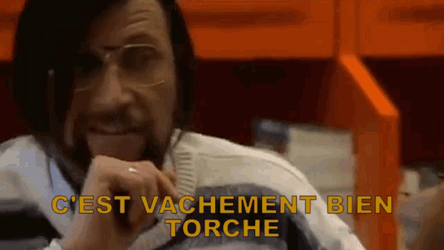 a man wearing glasses and a sweater with the words c'est vachement bien torche above him