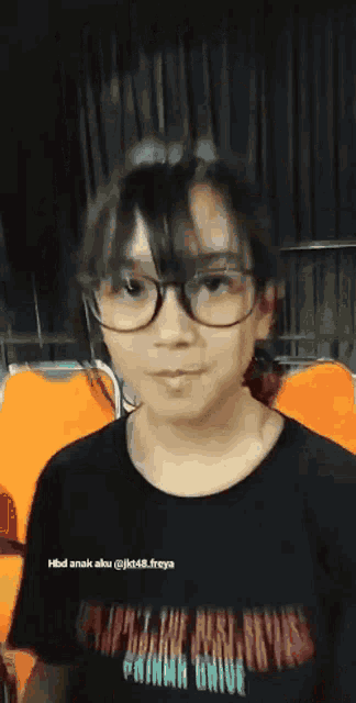 a girl wearing glasses and a black shirt that says primm drive on it