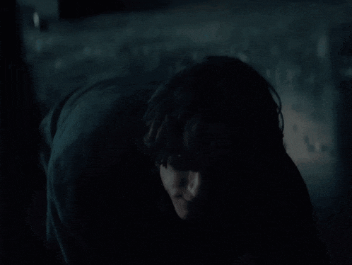 a man in a dark room with a man behind him