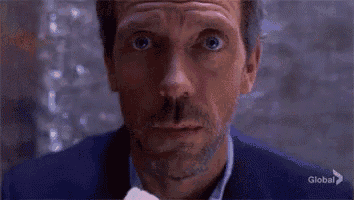 a man with a beard is eating something with his mouth open and a surprised look on his face .