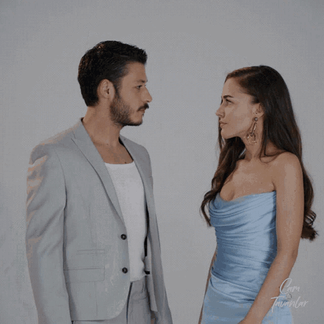 a man and a woman are standing next to each other and the woman is wearing a strapless blue dress