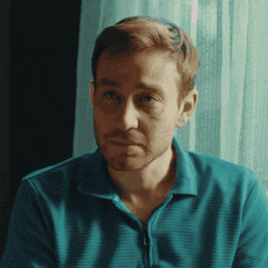 a man in a blue shirt looks at the camera