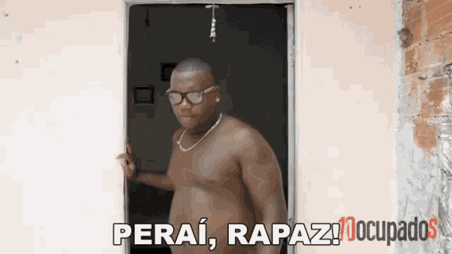 a man without a shirt is standing in a doorway with the words perai rapaz occupados below him